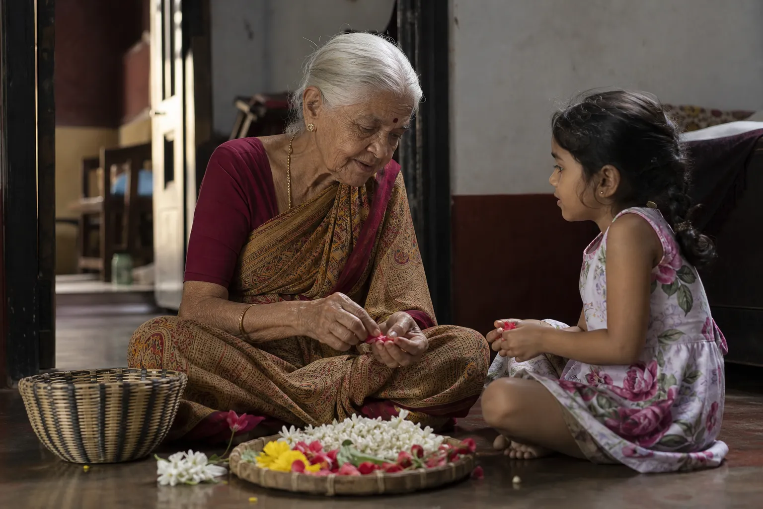 An older woman in the doorway of a traditional Karnataka home
