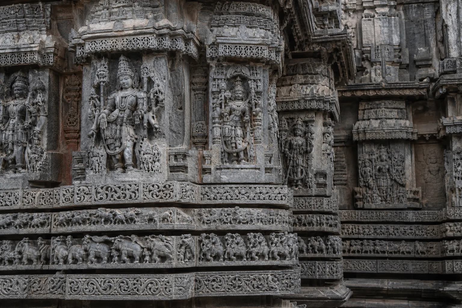 Carved stone detail on a Hoysala temple wall in Karnataka